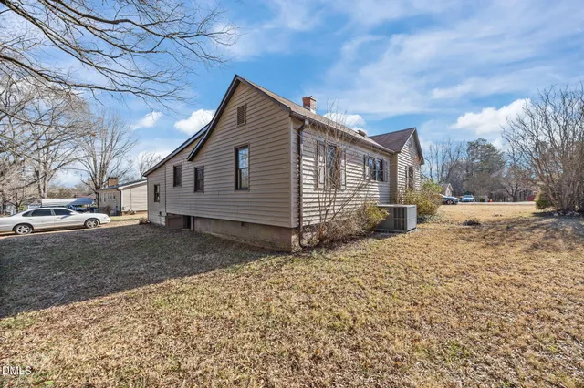 a view of a house with a large space and a large tree