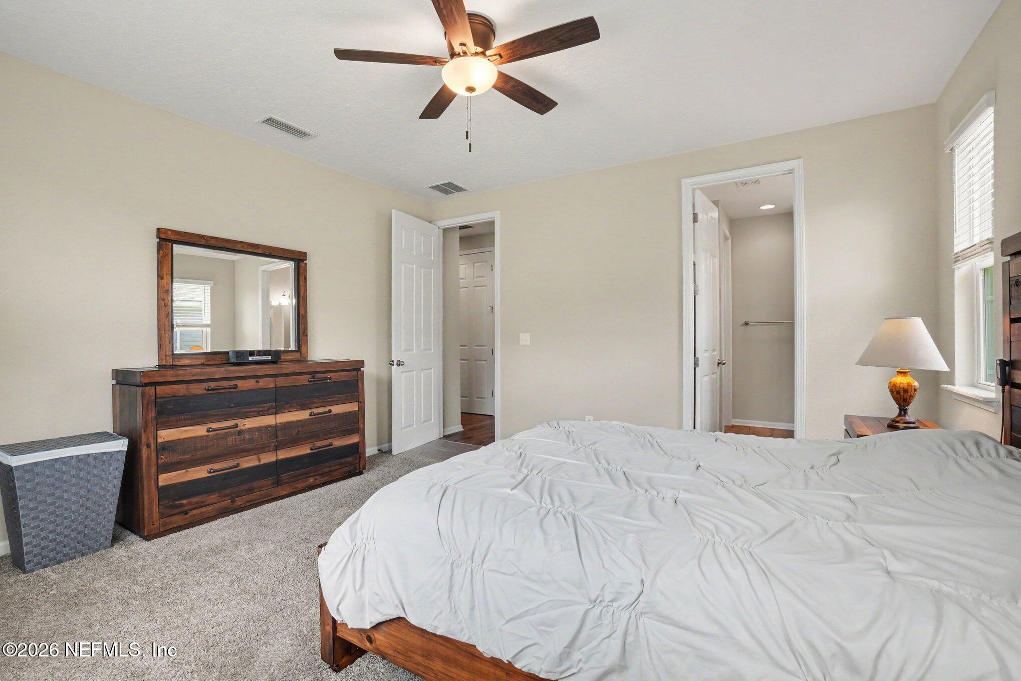 4630 Pine Ridge Parkway Middleburg, FL 32068 - Photo 16 of 35 a bedroom with a bed and a chandelier