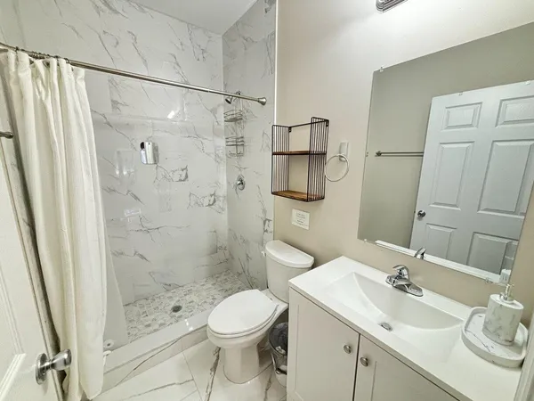 a bathroom with a sink a toilet and shower