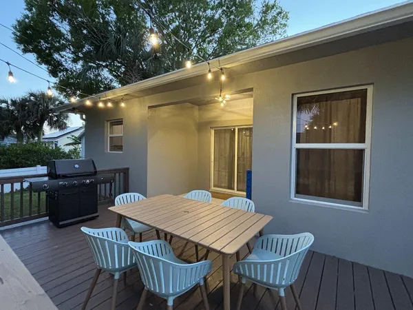 a view of a dinning table and chairs in patio of the house