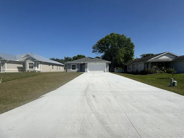 a view of house with yard and trees in the background