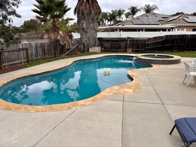 a view of a swimming pool with a patio and plants