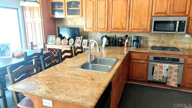 a kitchen with stainless steel appliances granite countertop a sink stove and cabinets