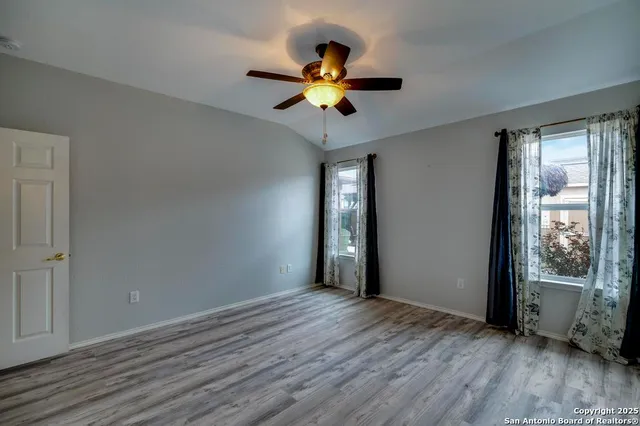 a view of wooden floor and a chandelier fan in a room