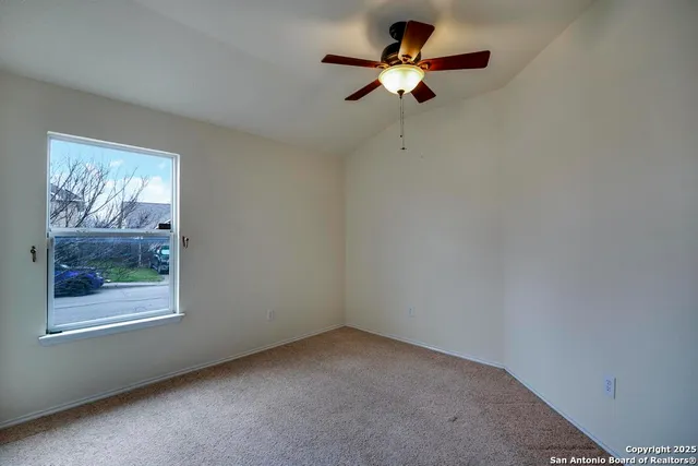 an empty room with a window and a fan