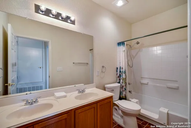 a bathroom with a sink toilet double vanity and shower