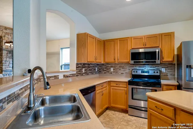 a kitchen with a sink and a stove top oven with wooden floor