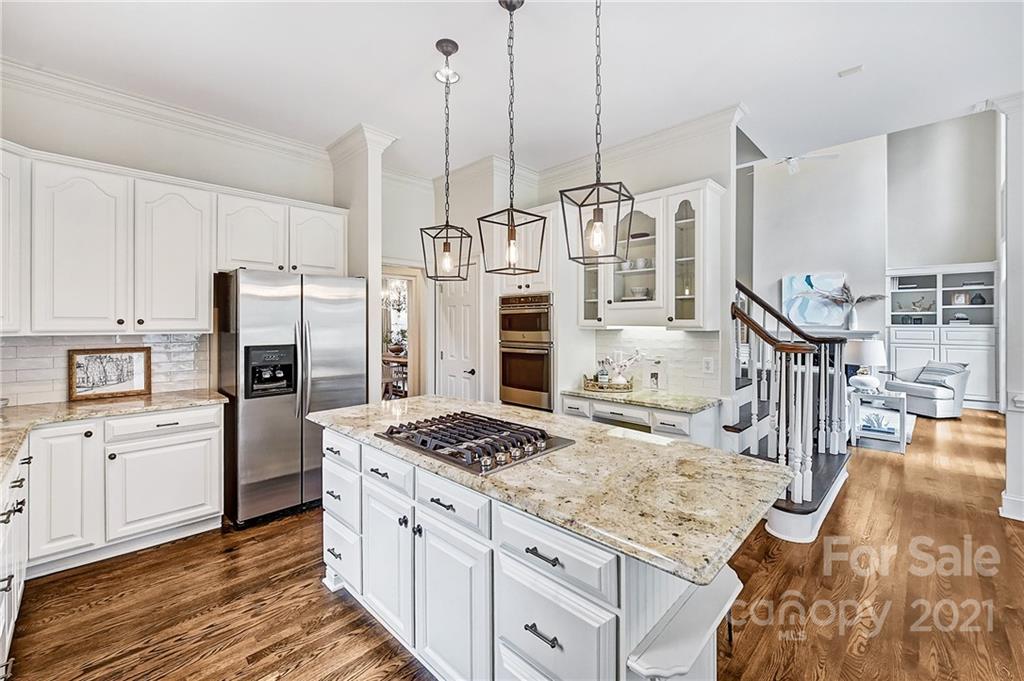 2826 Sharon Road Charlotte, NC 28211 - Photo 27 of 47 a kitchen with stainless steel appliances kitchen island granite countertop a refrigerator a stove and white cabinets with wooden floor