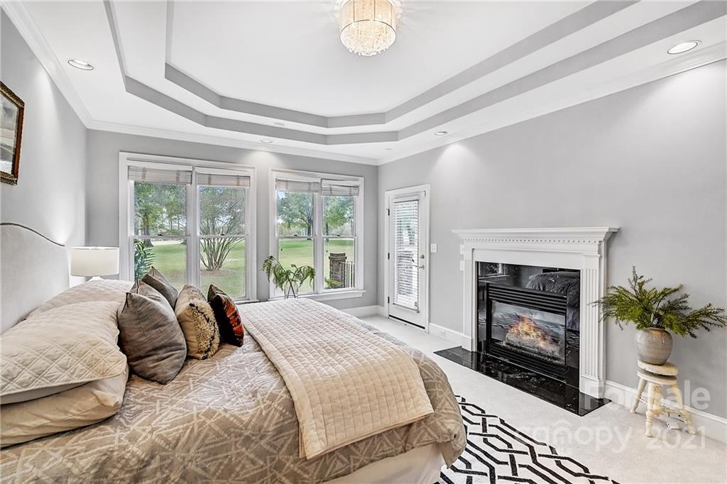 2826 Sharon Road Charlotte, NC 28211 - Photo 30 of 47 a spacious bedroom with a bed a fireplace and a large window