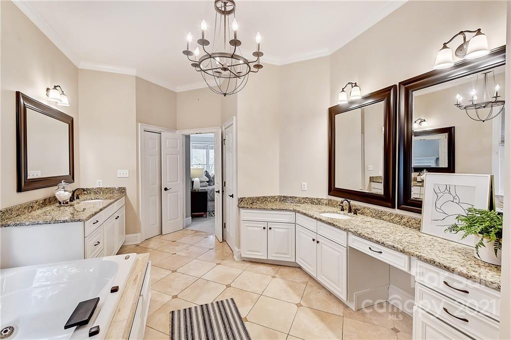 2826 Sharon Road Charlotte, NC 28211 - Photo 33 of 47 a spacious bathroom with a granite countertop sink a large mirror and a bathtub