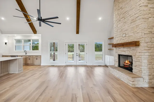 a view of an empty room with fire place and a window