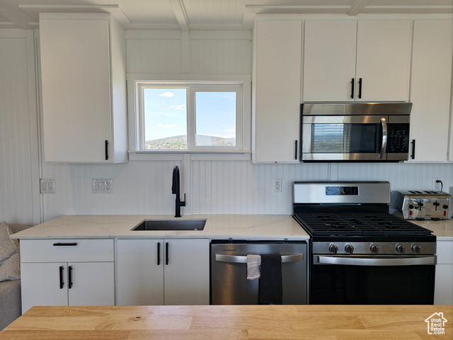 900 Altamont Road Evanston, WY 82930 - Photo 5 of 27 Kitchen featuring appliances with stainless steel finishes, light stone countertops, and white cabinets
