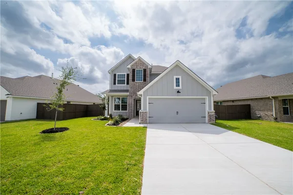 a front view of house with yard and garage