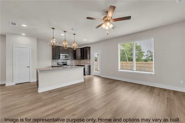 a view of kitchen with granite countertop cabinets stainless steel appliances and a fireplace