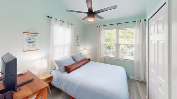 a bedroom with a bed ceiling fan and a window