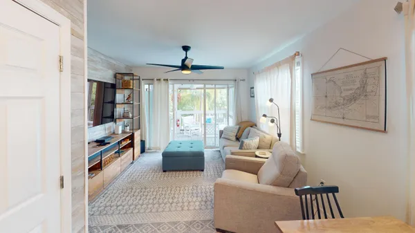 a living room with furniture a ceiling fan and a window