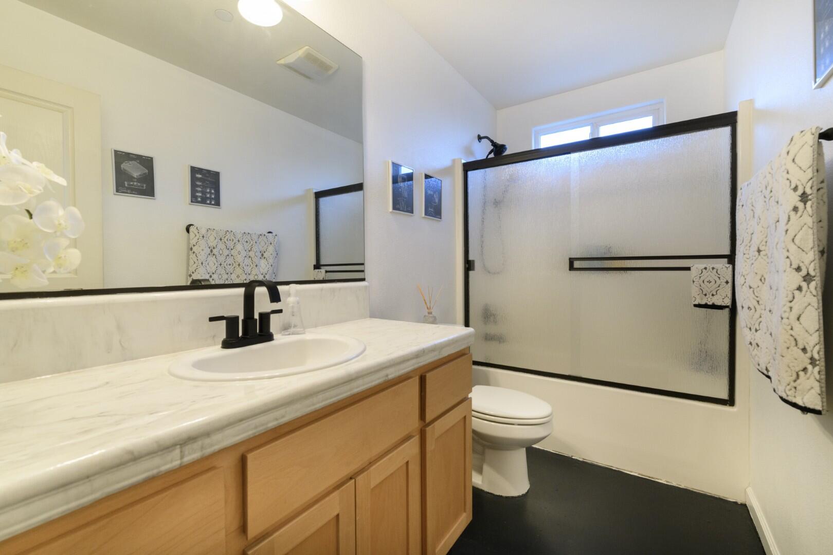 671 Valleybrook Drive Redding, CA 96003 - Photo 17 of 20 a bathroom with a granite countertop sink toilet and a mirror