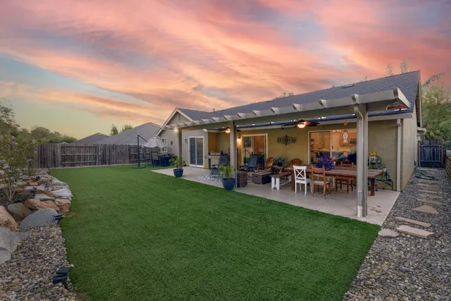 a view of a house with a backyard porch and sitting area