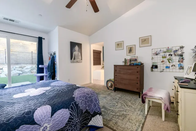 a bedroom with a bed a dresser and next to a window