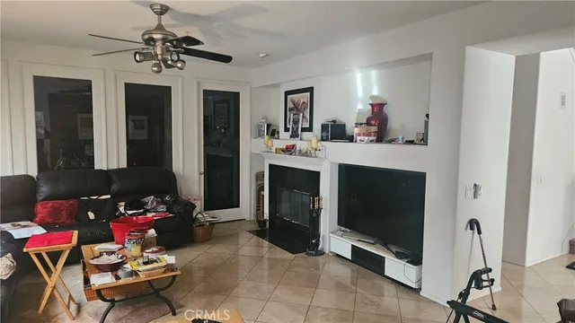 a living room with furniture potted plant and kitchen view
