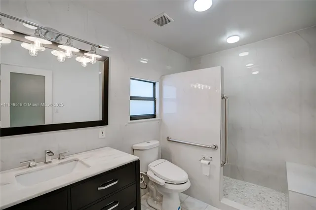 a bathroom with a toilet sink double vanity and mirror