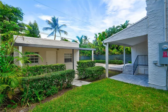 a view of a house with a yard and potted plants