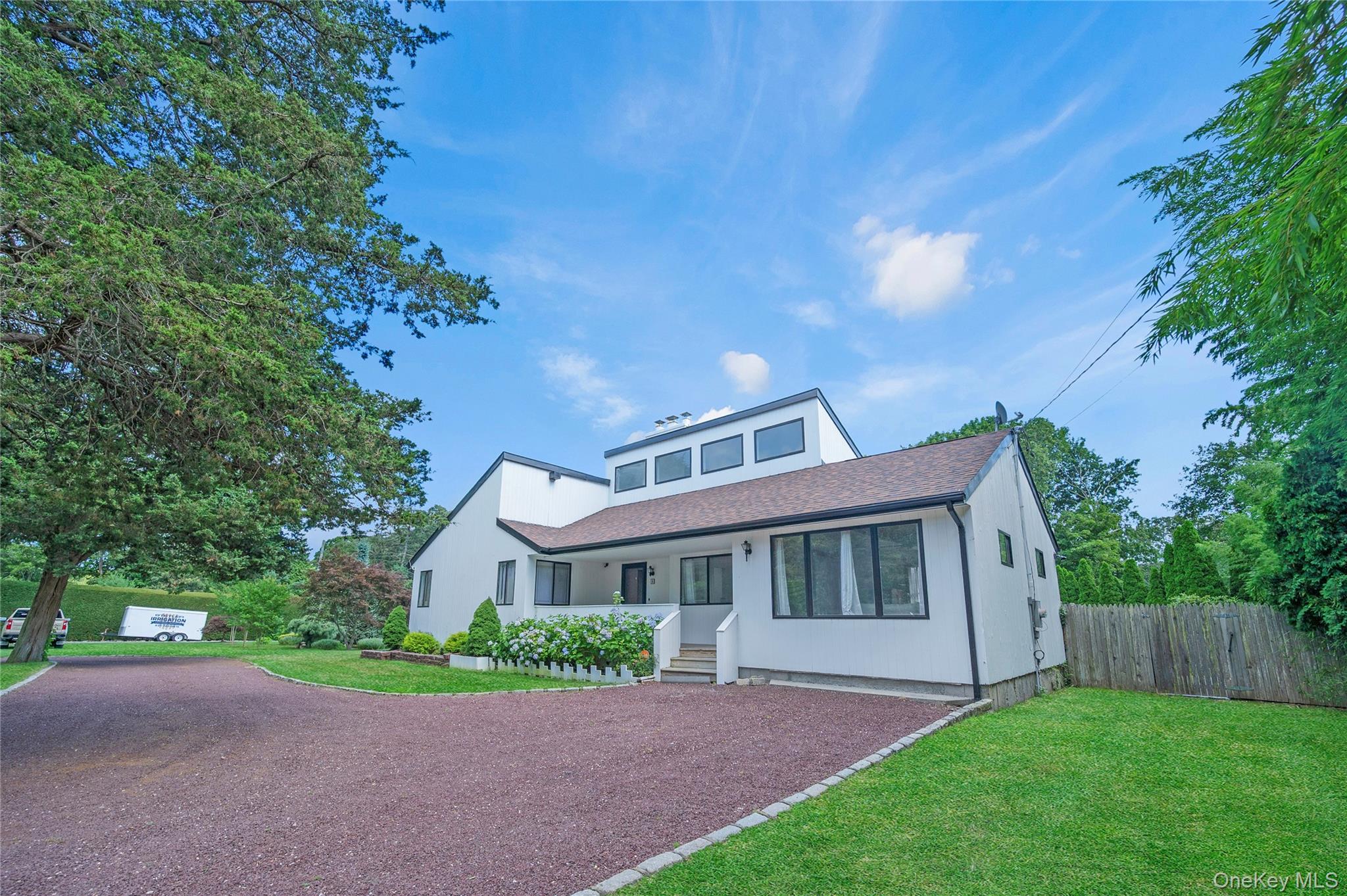 8 School Street Hampton Bays, NY 11946 - Photo 2 of 24 a front view of a house with a garden and yard