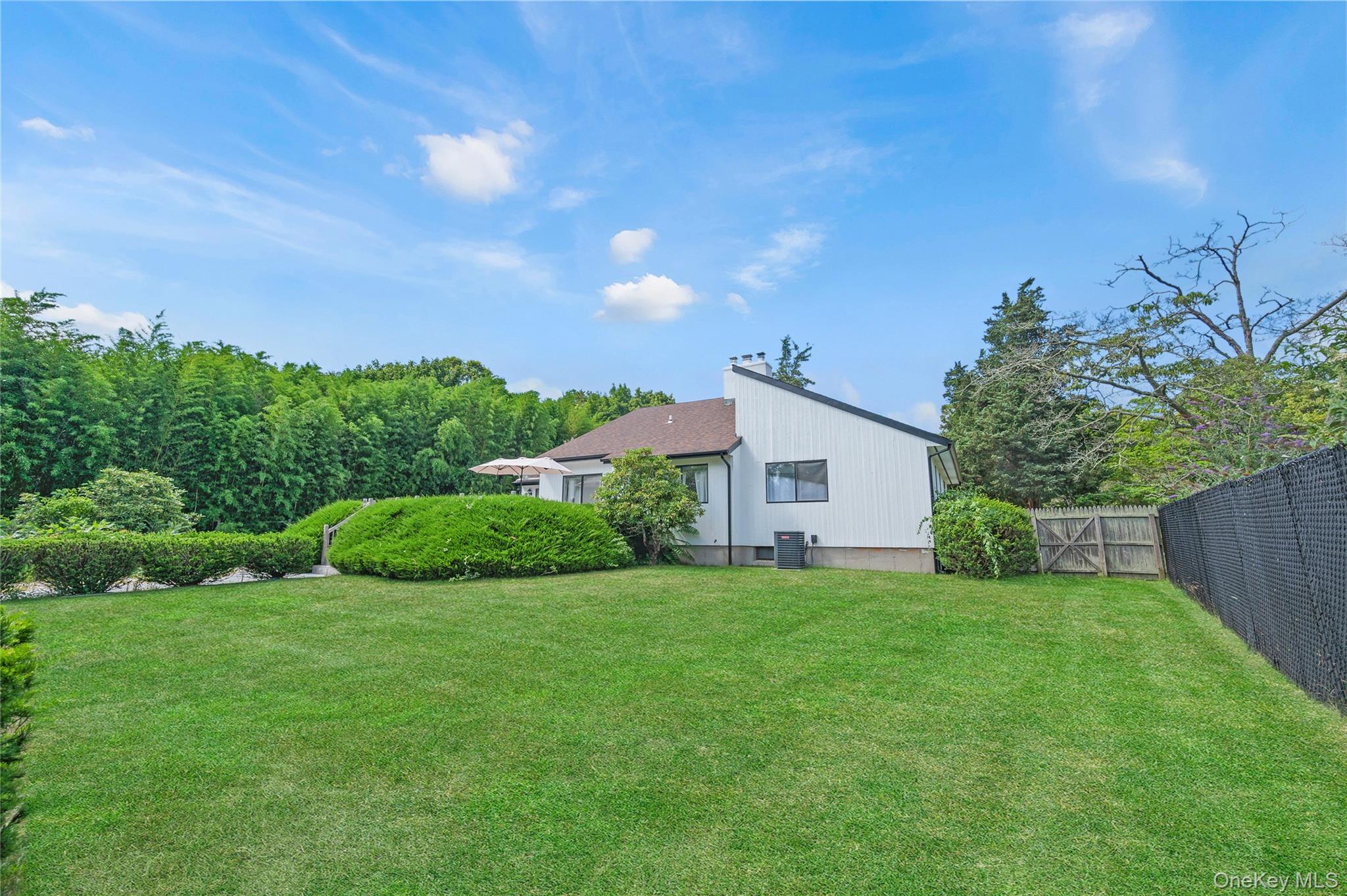 8 School Street Hampton Bays, NY 11946 - Photo 24 of 24 a view of a house with a big yard and potted plants