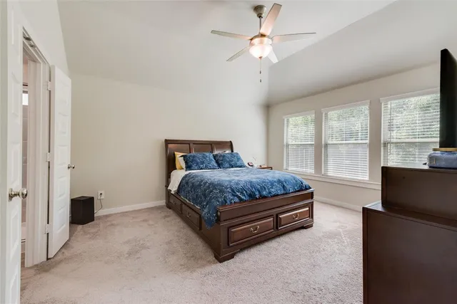 a bedroom with a large bed and a chandelier fan