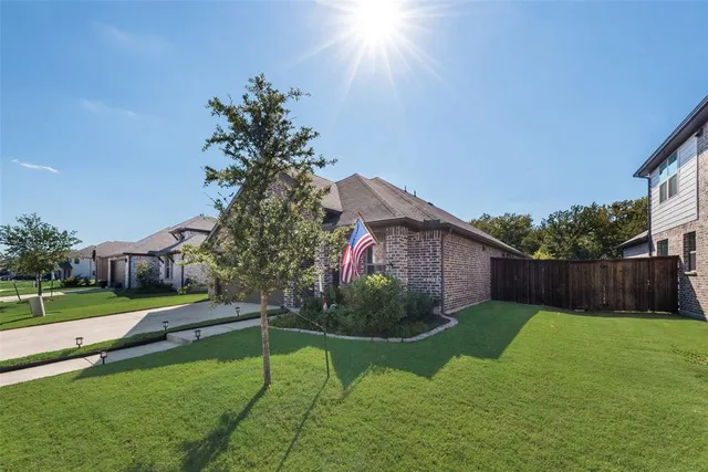 a view of a back yard with flower plants and wooden fence