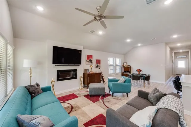 a living room with furniture a flat screen tv and a fireplace