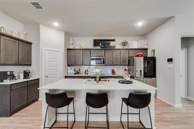 a kitchen with stainless steel appliances a sink and cabinets