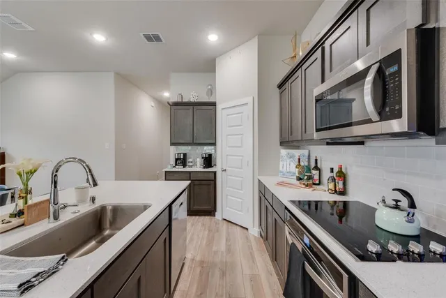 a kitchen with stainless steel appliances granite countertop a sink stove top oven and refrigerator