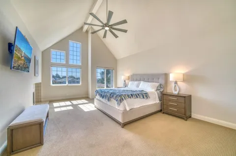 a spacious bedroom with a bed and a flat screen tv