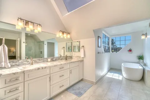a bathroom with a granite countertop sink mirror and cabinets