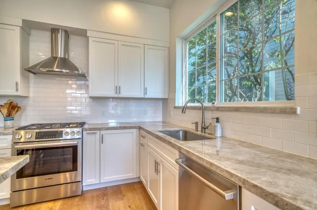 a kitchen with stainless steel appliances granite countertop a sink stove and cabinets