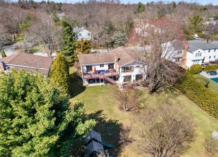 an aerial view of a house with a yard and mountain view in back