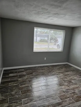 a view of a room with wooden floor and window