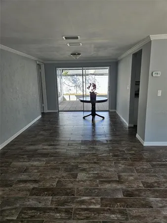 a view of empty room with window and wooden floor