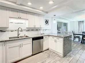 a kitchen with granite countertop a sink and cabinets