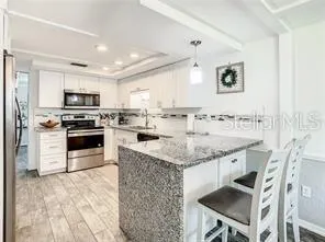 a kitchen with stainless steel appliances granite countertop a stove refrigerator and a sink