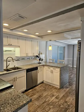 a kitchen with stainless steel appliances granite countertop a sink and cabinets