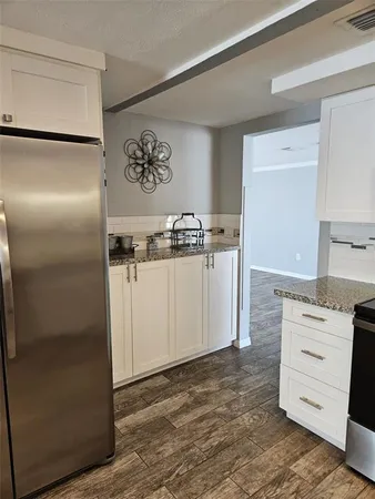 a kitchen with stainless steel appliances granite countertop a refrigerator and a stove
