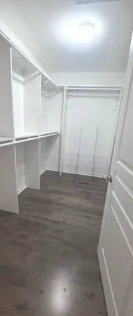 a view of walk in closet with empty racks