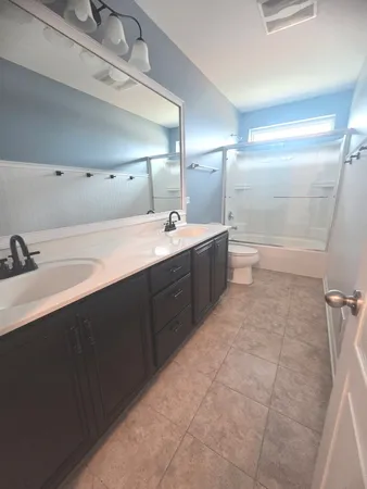 a spacious bathroom with a bathtub sink mirror and toilet