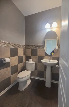 a bathroom with a toilet sink and mirror