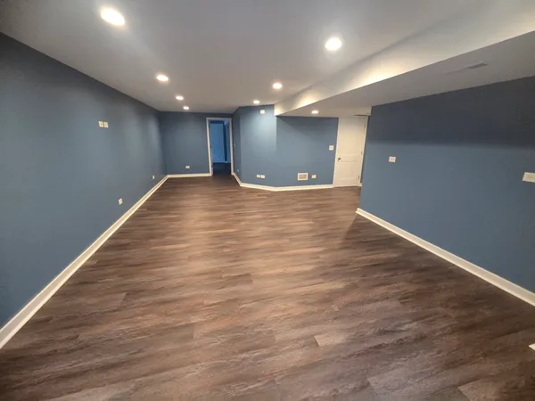 a view of empty room with wooden floor