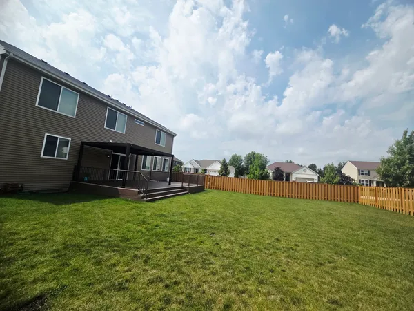 a view of a house with a yard deck and a small cabin