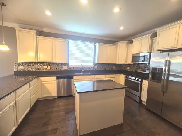 a kitchen with stainless steel appliances granite countertop a stove a sink and a refrigerator