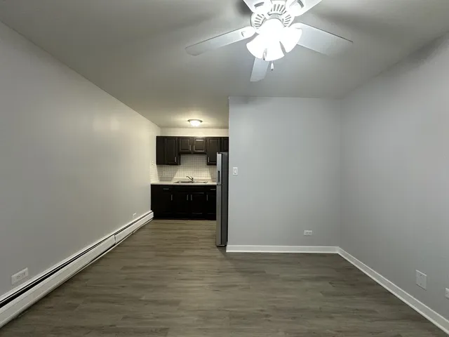 wooden floor in an empty room with a kitchen